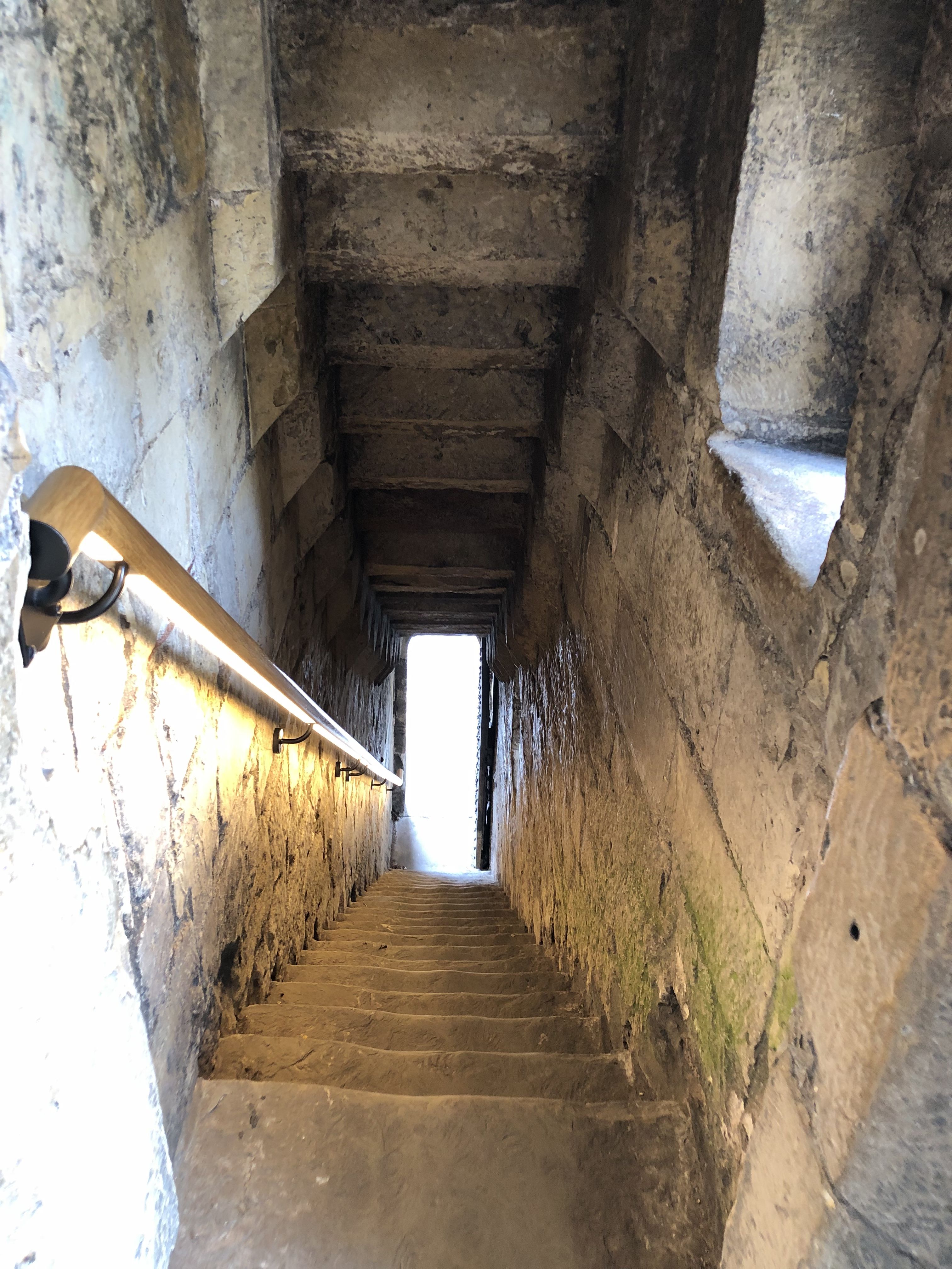 Sheltered steps with banister leading the ancient walls down to street level