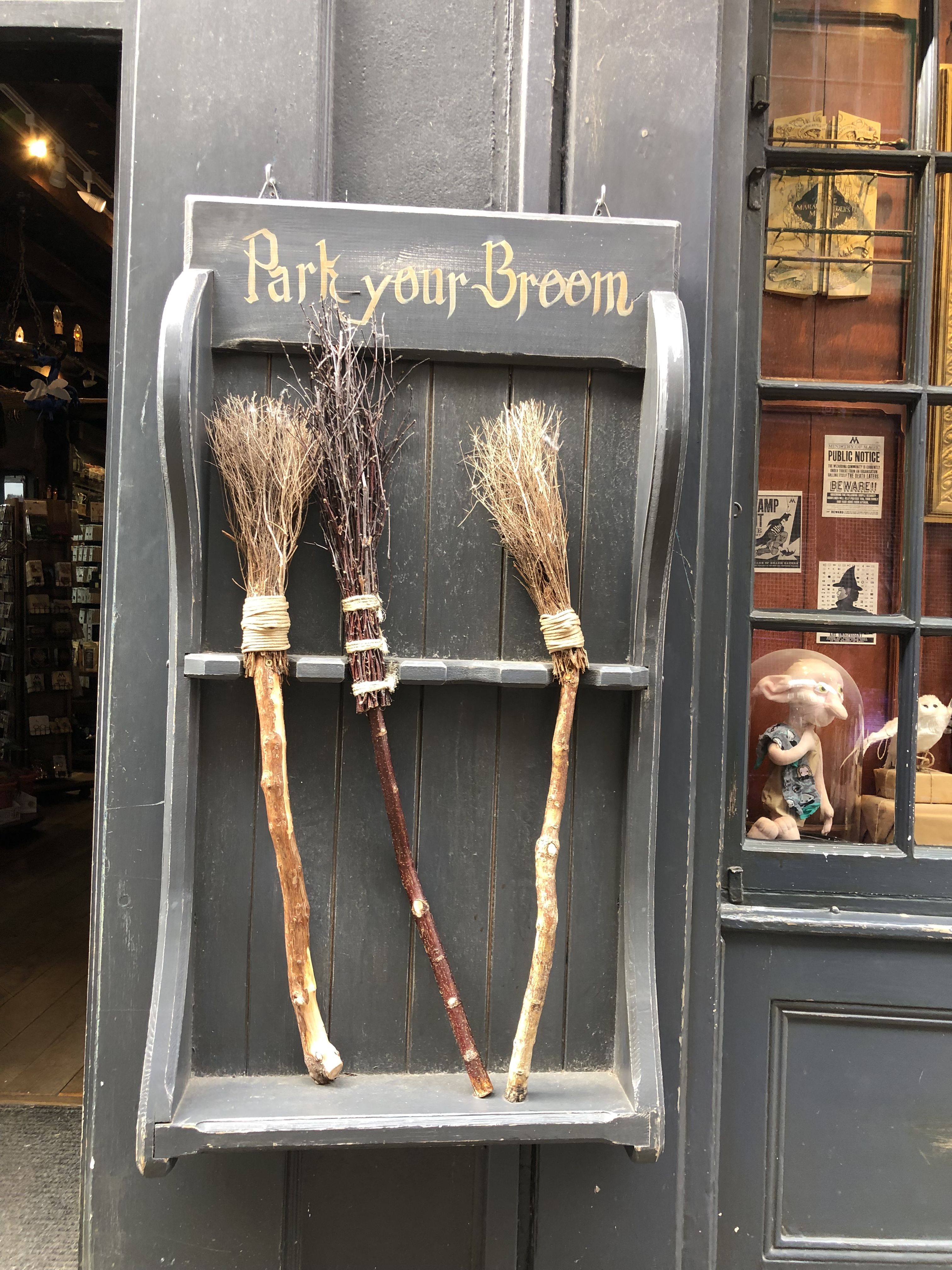 Fake flying broomsticks 'parked' in a shelf on the wall