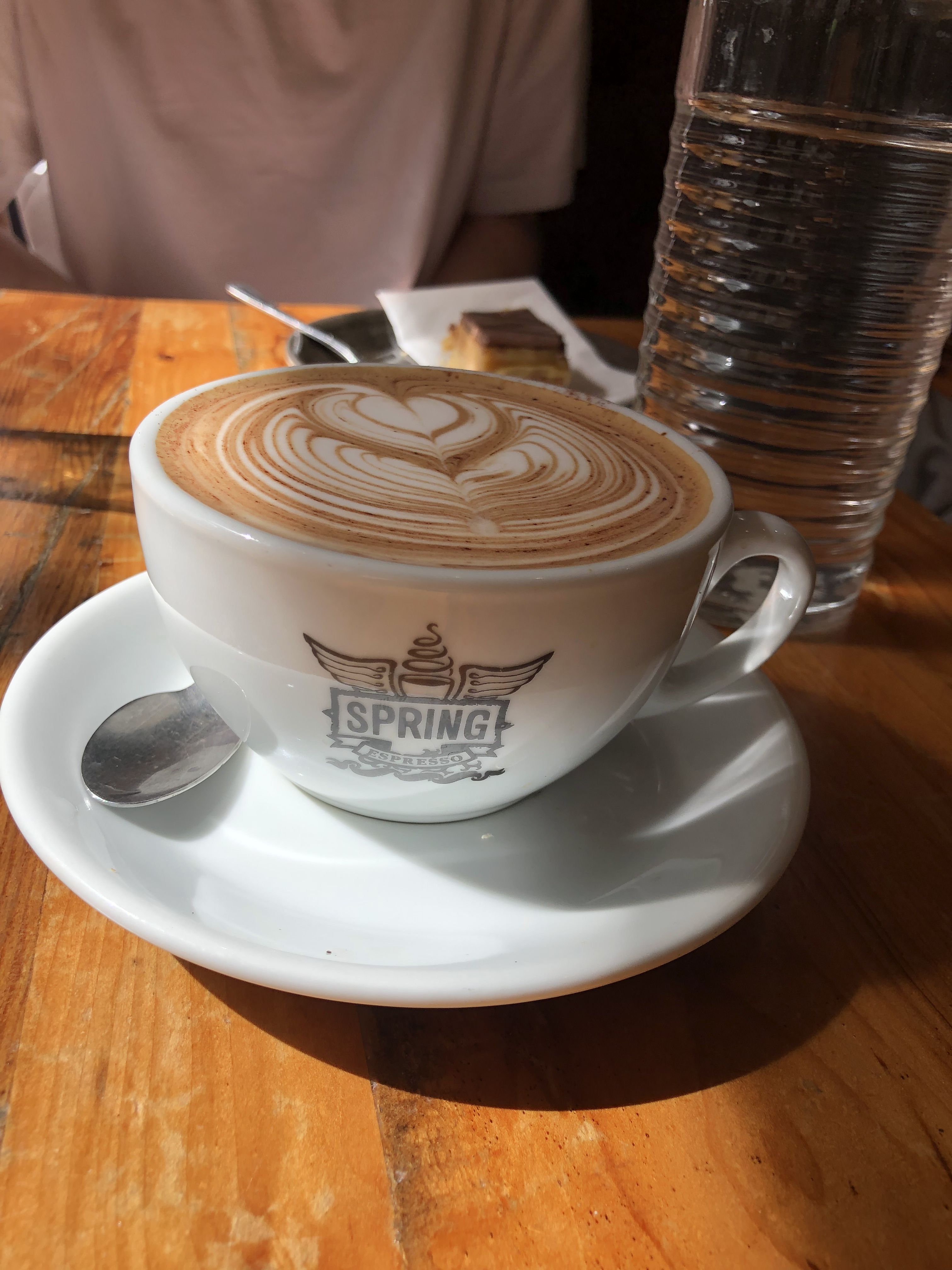 A coffee, with latte art, in a white branded cup with